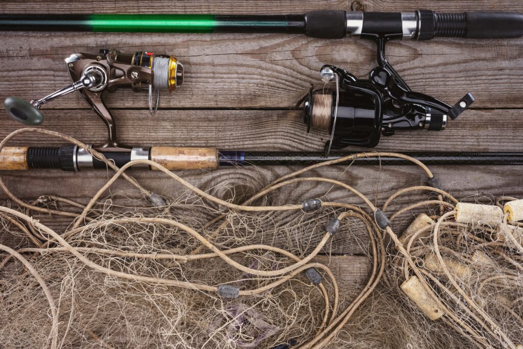 top view of fishing rods and fishing net on wooden planks